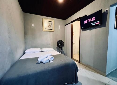 a bedroom with a bed with two towels on it at Espaço Verano - Suítes in Niterói