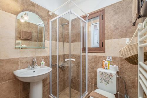W łazience znajduje się prysznic, umywalka i toaleta. w obiekcie Celine Deluxe Apartment w mieście Leukada (miasto)