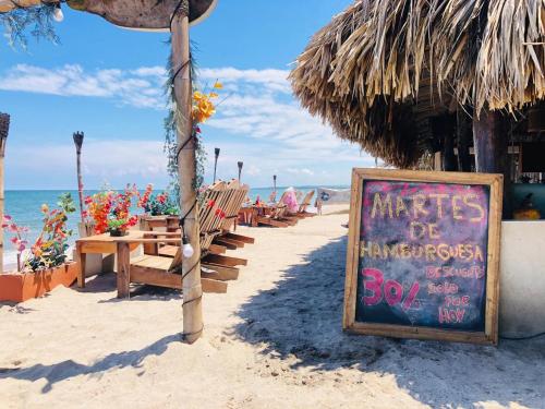 a sign on the beach with benches and a beach at Finca Escondida in Palomino