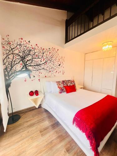 a bedroom with a white bed with a red blanket at Hotel Reserva Monarca in Salento