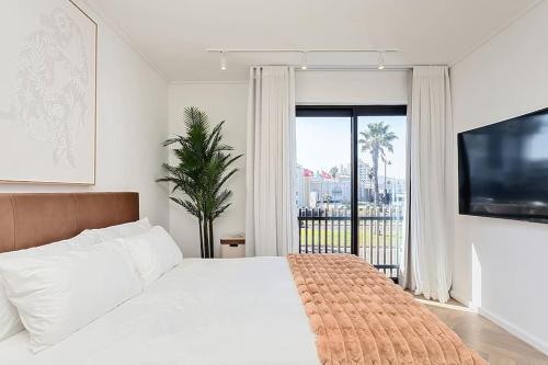 a bedroom with a white bed and a large window at Chic Minimalist City Retreat in Cape Town