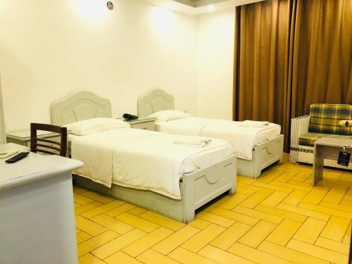a hospital room with two beds and a chair at فندق اربد بلازا in Irbid