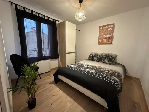 - une chambre avec un lit, une fenêtre et une plante dans l'établissement Superbe appartement “l’Eden”Clim, proche remparts, à Avignon
