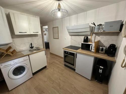 une cuisine avec un lave-linge et un lave-linge dans l'établissement Superbe appartement “l’Eden”Clim, proche remparts, à Avignon