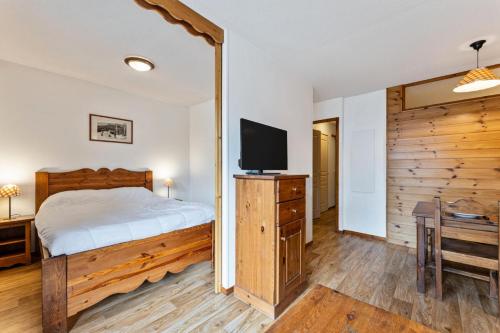 une chambre avec un lit et une télévision à écran plat dans l'établissement Résidence Les Hauts De Preclaux - Appartement cosy pour 6 au coeur des Orres 1800 MAE-9951, aux Orres