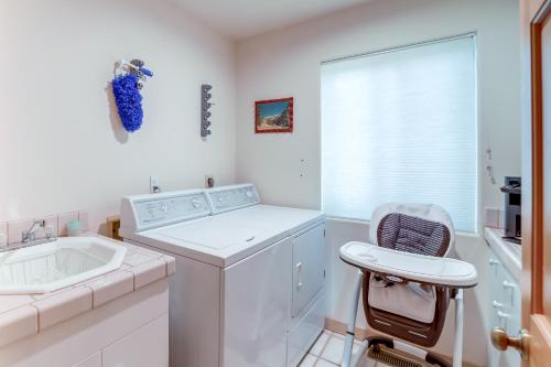 a white laundry room with a washing machine and a chair at Hot Tub, Fire Pit and Deck Chic Arizona Retreat in Pine