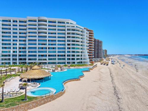 a large building on the beach next to the beach at Oceanfront Vibes Iconic Beachside Getaway in Puerto Peñasco