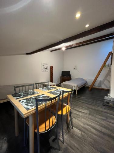 une pièce avec une table, des chaises et un lit dans l'établissement Le Thiers I, à Pont-à-Mousson