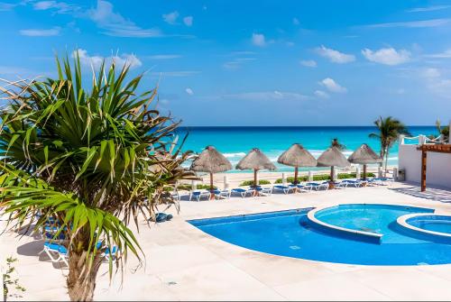 a resort with a swimming pool and the beach at Marlin by Andiani Travel in Cancún