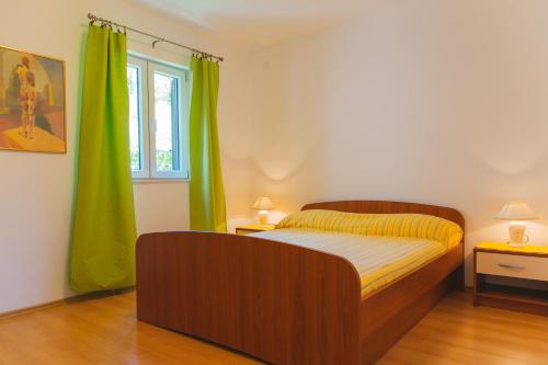 um quarto com uma cama e uma cortina verde em Apartments Dada em Omiš