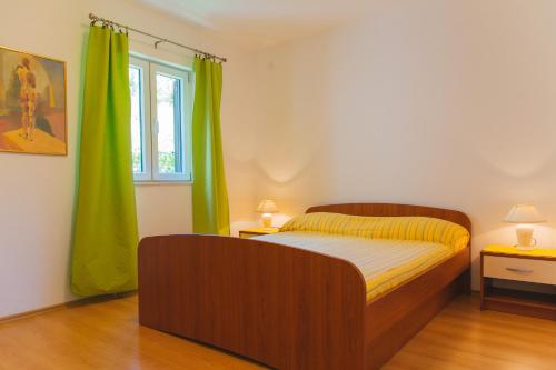 a bedroom with a bed and a green curtain at Apartments Dada in Omiš