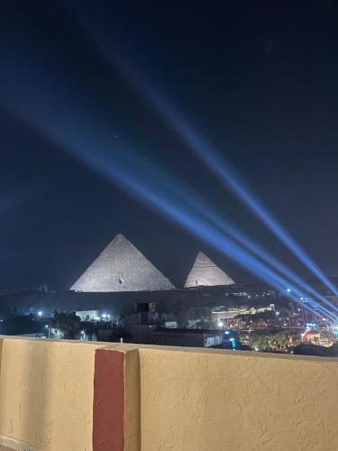 a view of the pyramids of giza at night at Cheristo pyramids view inn in Cairo