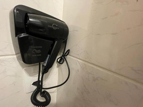 a black phone is hanging on a wall at Villa Bilac - Amplos Studios 2km da Vila Germânica in Blumenau