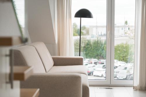 a living room with a chair and a window at The Serviced - Design Apartments in Stuttgart