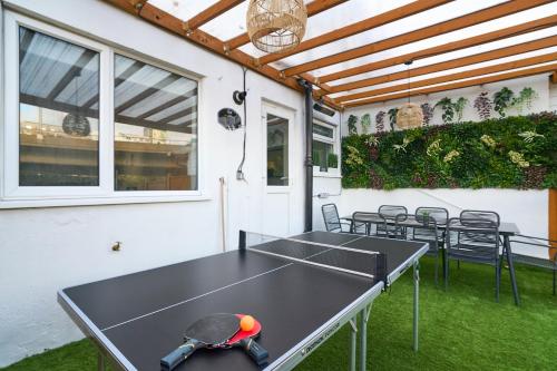 a ping pong table on a patio with chairs at City Air Apartments - GREENWICH - O2 ARENA AND FREE PARKING in London