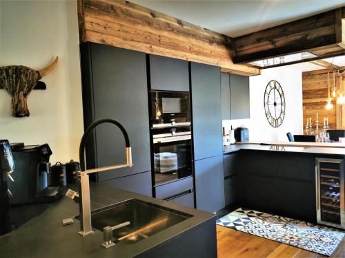 une cuisine avec un évier et un plan de travail dans l'établissement Résidence PremiÈre Loge - Très bel appartement spacieux, lumineux avec vue sur la station MAE-3481, aux Gets