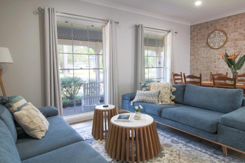 a living room with two blue couches and a table at 7Palms Retreat at Jervis Bay in Vincentia