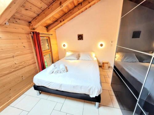 - une chambre avec 2 lits dans une pièce dotée de murs en bois dans l'établissement Résidence Le ChampÉ - Appartement paisible à deux pas du centre MAE-3701, aux Gets