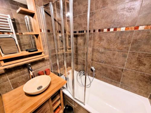 une salle de bain avec une douche, un lavabo et une baignoire dans l'établissement Résidence Le ChampÉ - Appartement paisible à deux pas du centre MAE-3701, aux Gets