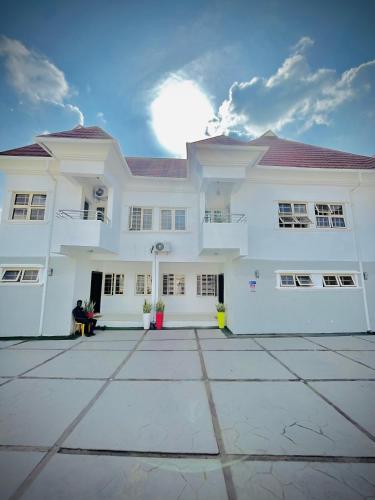 a large white house with a large courtyard at Bots Three Bedroom Luxury Apartment in Ilorin