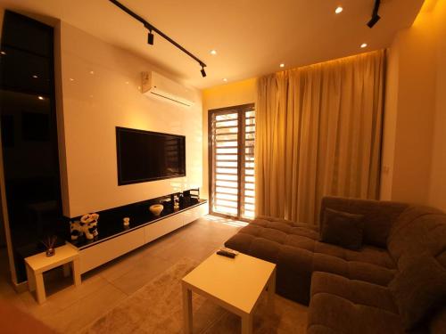 a living room with a couch and a flat screen tv at Madinity B8 - Fantasy Studio in Madinaty