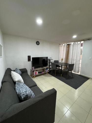 a living room with a couch and a table at Apartamento para 4 personas CDMX in Mexico City