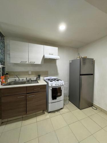 a kitchen with a stove and a refrigerator at Apartamento para 4 personas CDMX in Mexico City