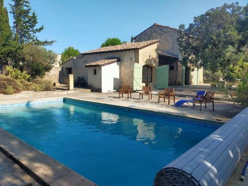 une grande piscine devant une maison dans l'établissement Mas intérieur rénové 4 chambres piscine, à Castillon-du-Gard