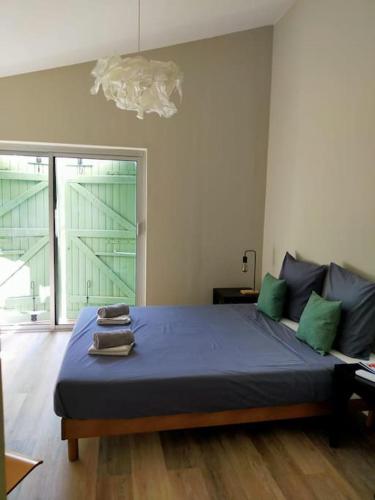 - une chambre avec un lit doté de draps bleus et d'oreillers verts dans l'établissement Mas intérieur rénové 4 chambres piscine, à Castillon-du-Gard