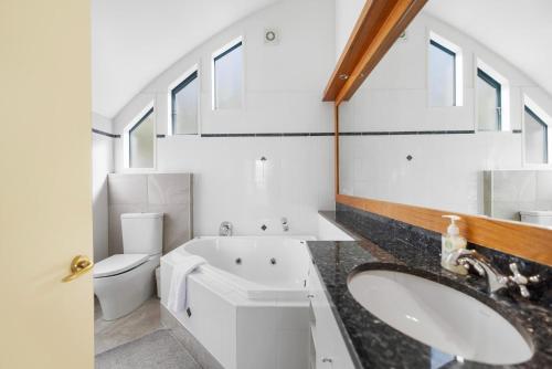 a bathroom with two sinks and a toilet at Belfast Retreat - Views and Spa Pool in Queenstown