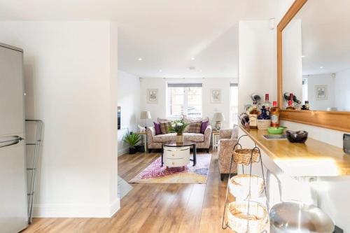 a kitchen and living room with white walls and wooden floors at Braeburn Cottage Central Bewdley- 2 Parking Spaces in Bewdley