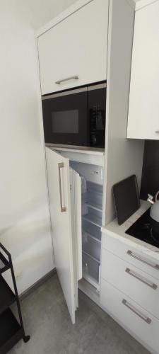 a white kitchen with a microwave and a stove at Nowa Osada in Łącko