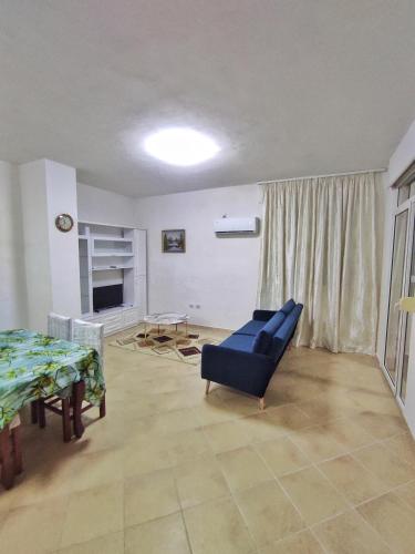 a living room with a blue couch and a table at Noor Apartment in Durrës