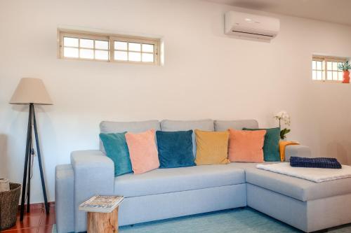 a blue couch with colorful pillows on it in a living room at Casa da Valentina in Fafe