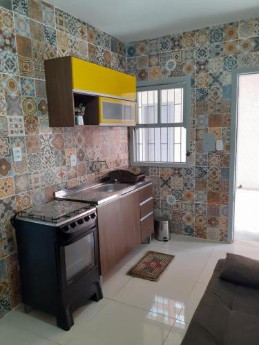 a kitchen with a stove top oven in a room at Ótimo e bem localizado - Centro do Mar Grosso - Laguna in Laguna