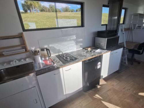 a kitchen with white cabinets and a sink and a window at Trailer home with stunning view in Brighton