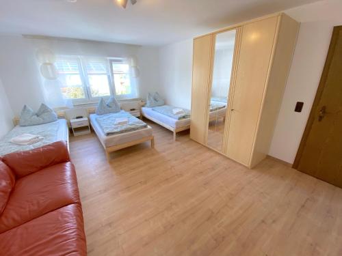 a living room with a leather couch and a living room with a couch at IV Apartment 12 Personen - Monteurzimmer - Ferienwohnung - Kronwieden in Loiching