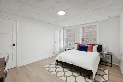 a bedroom with a bed and two windows at East 419i Modern Suite I Pool I Gym in Rochester