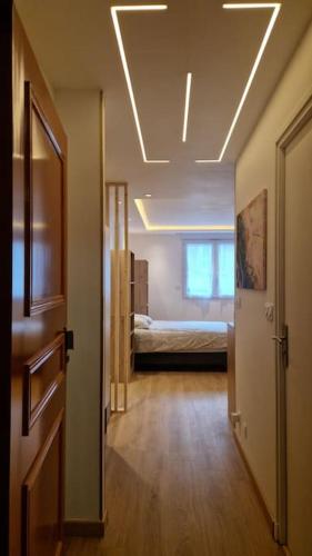 une chambre avec un couloir avec un lit et une chambre avec un couloir dans l'établissement L'écrin Doré, à Vernon