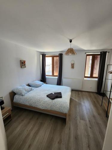 - une chambre avec un lit, du parquet et des fenêtres dans l'établissement Séjour au cœur de Saverne, à Saverne