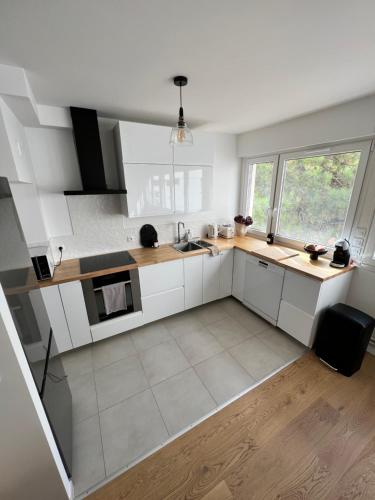 une cuisine avec des placards blancs et une grande fenêtre dans l'établissement Luxury apartment 16', à Paris