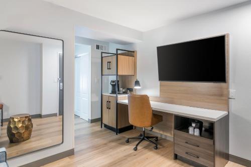 a room with a desk with a television and a chair at Country Inn & Suites By Radisson, Savannah Airport, GA in Savannah