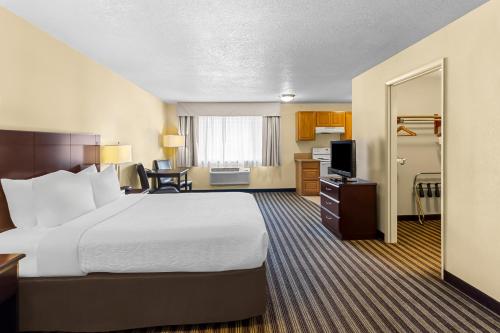 a hotel room with a large bed and a television at Quality Inn & Suites Vancouver - Hazel Dell in Vancouver