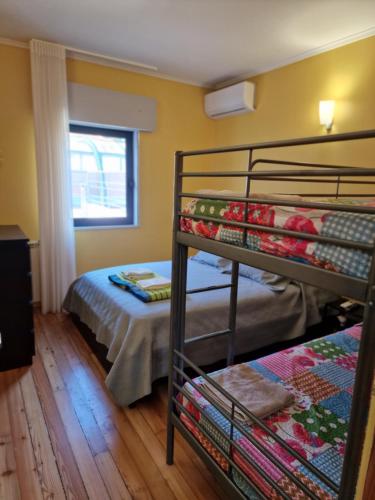 a bedroom with two bunk beds and a bed at Casa Cabanas piscina água quente de sal in Viana do Castelo