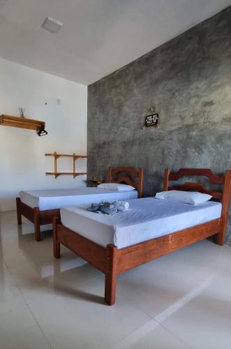 two twin beds in a room with a wall at Lazer Paracuru in Paracuru