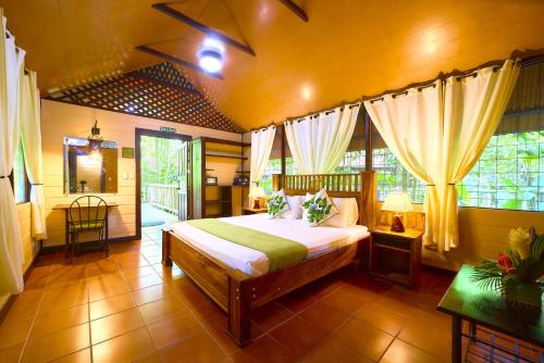 ein Schlafzimmer mit einem Bett in einem Zimmer in der Unterkunft Aninga Lodge in Tortuguero