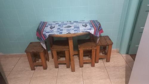 a table and two stools next to a table with at Kit no centro de Mongagua em frente o mar in Mongaguá