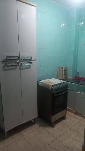 a kitchen with a refrigerator and a stove at Kit no centro de Mongagua em frente o mar in Mongaguá