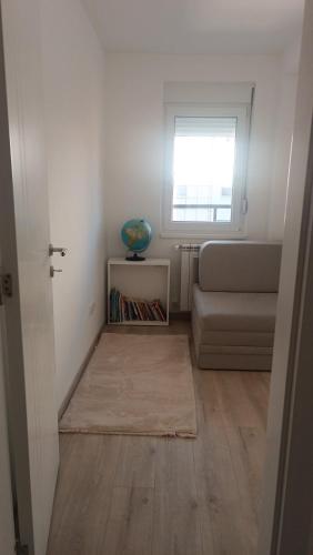 a living room with a couch and a window at Central City Stay - Apartment Alex in Šabac