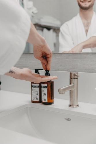 a person holding a bottle of spices in a kitchen at Balcomo, a Ramada by Wyndham in Penticton